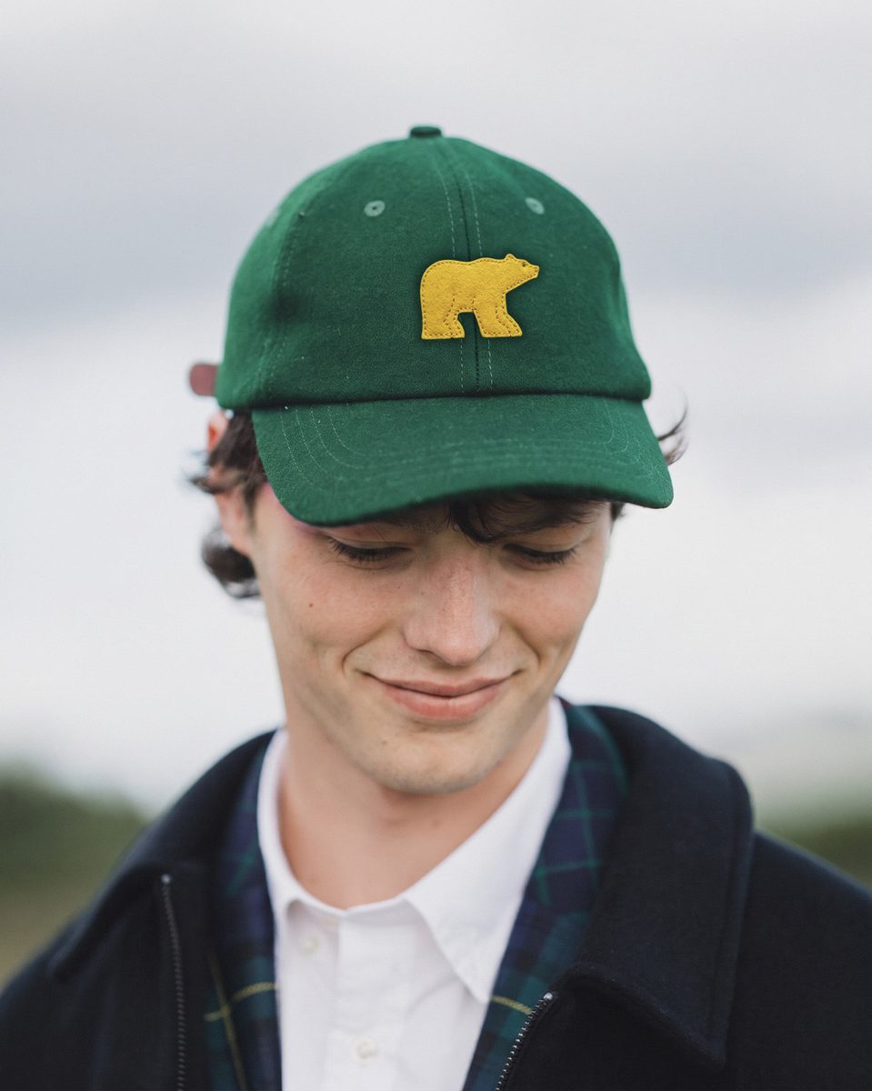 Man in a forest green wool cap with a felt Golden Bear mark